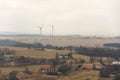 Wind turbines power station on cloudy foggy winter day Royalty Free Stock Photo