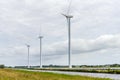 Wind turbines and solar panels along a canal in the countryside Royalty Free Stock Photo