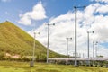 Wind turbines with solar panels farm on mountanis landscape against blue sky with clouds background Royalty Free Stock Photo