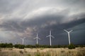 Wind turbines spin in strong winds as a dark storm approaches Royalty Free Stock Photo