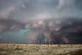 Wind turbines spin in strong winds as a dark storm approaches Royalty Free Stock Photo