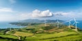 Wind turbines stand atop lush green hills with a panoramic view of the coast and sea, symbolizing sustainable energy generation Royalty Free Stock Photo