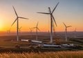 Wind turbines stand tall on a hilly landscape during sunset. Royalty Free Stock Photo