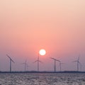 Wind turbines and sun in colorful sky
