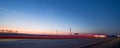 Wind turbines at sunset along highway morning commute Royalty Free Stock Photo