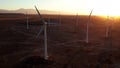 Wind Turbines at Sunset. Windenergy farm with many turbine windwill generating alternative energy. Windy park