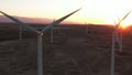 Wind Turbines at Sunset. Windenergy farm with many turbine windwill generating alternative energy. Windy park