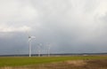 Wind turbines, three modern windmills on a green field Royalty Free Stock Photo