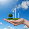 Wind turbines with tree in female hand Royalty Free Stock Photo