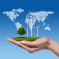 Wind turbines with tree in female hand Royalty Free Stock Photo