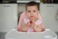 Baby girl eating strawberry on highchairs Royalty Free Stock Photo