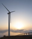 Wind turbines at the wind farm at sunset and sun above the clouds Royalty Free Stock Photo