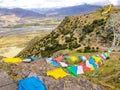 Wind wavering Buddhist Tibetan Chinese prayer flags with Sanskrit calligraphy written decorating mountain valley in Tibet, China