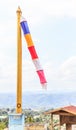 Wind Wavering colorful Buddhist flag in Buddhist temple with blank blue sky background. Symbol of Worship, Belief, Culture,