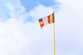 Wind Wavering colorful Buddhist flag in Buddhist temple with blank blue sky background. Symbol of Worship, Belief, Culture,