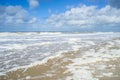 Wind and waves create foam on the beach Royalty Free Stock Photo
