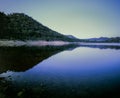 Hill and landscape reflecting in lake Windamere Dam New South Wales Australia at blue hour