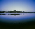 Hill and landscape reflecting in lake Windamere Dam New South Wales Australia at blue hour