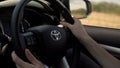 Driving Toyota SUV car. Man driver hands on steering wheel. Highway road.