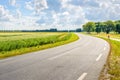 Winding asphalt road through a rural area in the summer season Royalty Free Stock Photo