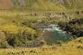 A winding bed of a shallow and stormy river with rocky banks flowing through a picturesque valley on a sunny autumn day Royalty Free Stock Photo