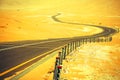 Winding black asphalt road through the sand dunes of Liwa oasis, United Arab Emirates Royalty Free Stock Photo