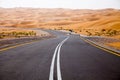 Winding black asphalt road through the sand dunes of Liwa oasis, United Arab Emirates Royalty Free Stock Photo