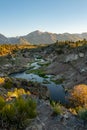 Winding bubbling river at Hot Creek Geological Site in Mammoth Lakes California, with the Eastern Sierra Nevada mountains in Royalty Free Stock Photo