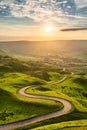 Winding country road leading to Edale in the English Peak District with beautiful golden light shining through valley. Royalty Free Stock Photo