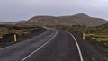 Winding country road with markings between moss covered lava fields of volcanic stones near Grindavik, Reykjanes, Iceland.