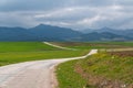 A winding country road, and mountains in background Royalty Free Stock Photo