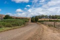 Winding countryside unsealed road among farms nature background