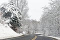 winding, curved road through woods and forest covered in fresh Winter white snow Royalty Free Stock Photo