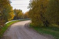 Winding dirt road through the autumn forest. Beautiful autumn landscape Royalty Free Stock Photo