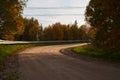 Winding dirt road through the autumn forest. Beautiful autumn landscape Royalty Free Stock Photo