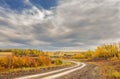 Winding dirt road in autumn landscape Royalty Free Stock Photo