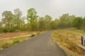 Winding gravel road through temperate forest at Jhargram, west bengal, India Royalty Free Stock Photo