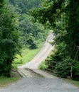 Winding, hilly, road crosses a wooden bridge Royalty Free Stock Photo