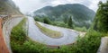 Winding mountain road in a forest. Foggy wet weather and slippery asphalt. Alps, Slovenia. Royalty Free Stock Photo