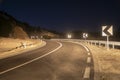 A winding mountain road at night illuminated by car headlights Royalty Free Stock Photo