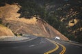 Winding Mountain road with white truck towing travel trailer in the distance climbing the incline