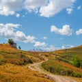 Winding path through mountains. Trekking mountain trail. Bright panoramic alpine landscape with dirt road among grasses in