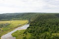 Winding river and forest, aerial panoramic view. Summer green valley landscape with rural houses and riverbed, top view Royalty Free Stock Photo