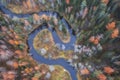 Winding river in form of yin and yang in autumn colorful forest top view