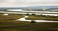 Winding River Through a Vast Marshland Under a Cloudy Sky (1115 Royalty Free Stock Photo