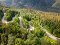 Winding road through the forest, from high mountain pass, in summer time. Aerial view by drone. Brasov, Romania. This view is Royalty Free Stock Photo