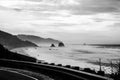 a winding road going past the ocean with tall rocks in the distance Royalty Free Stock Photo