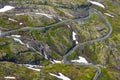 Winding road in a green landscape with snow patches Royalty Free Stock Photo