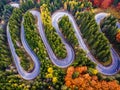 Winding road from high mountain pass, in autumn season, with orange forest Royalty Free Stock Photo