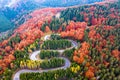 Winding road from high mountain pass, in autumn season, with orange forest